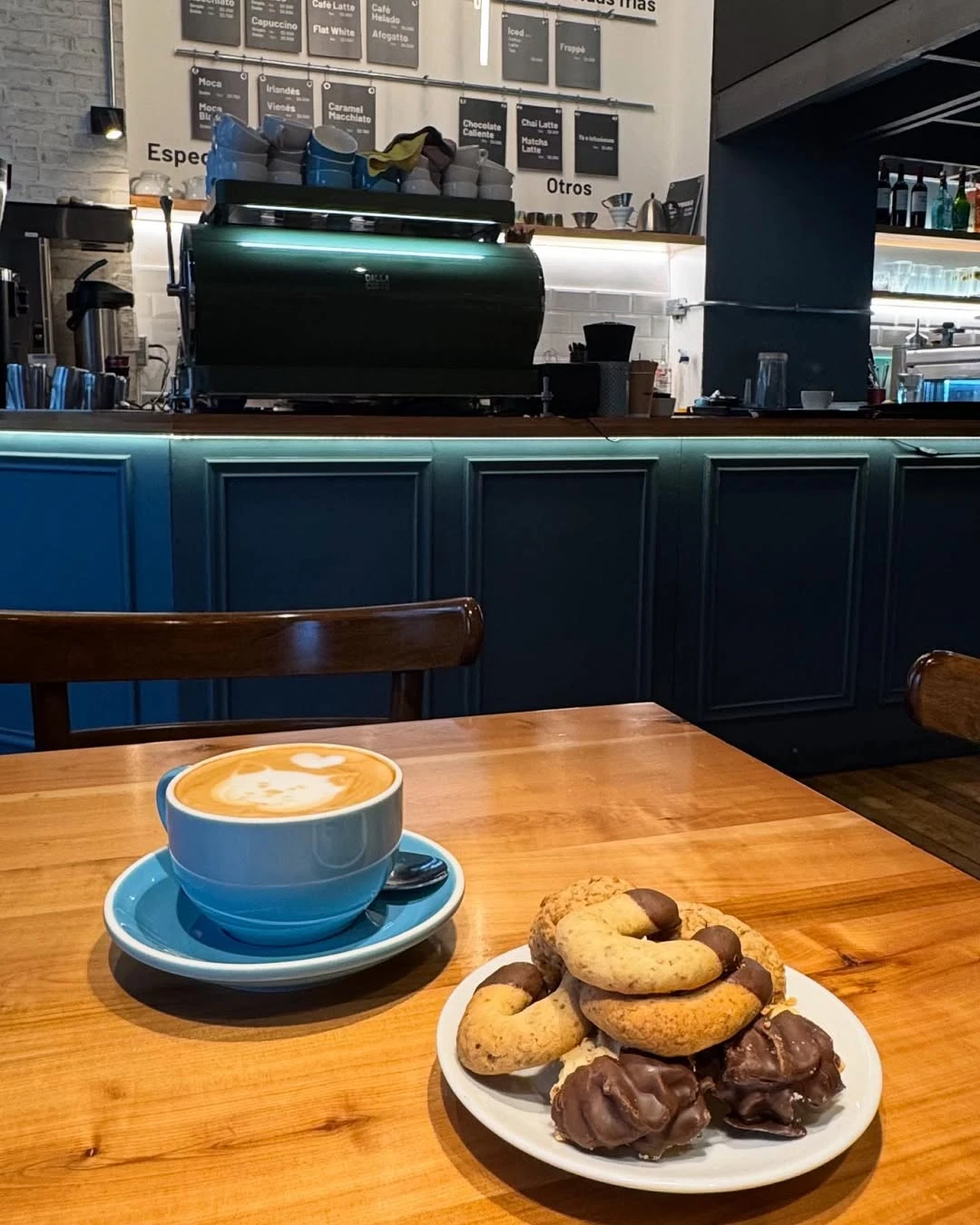 Primer plano de un plato de hot cakes americanos de Café Tapiz, cubiertos con un huevo frito, tocino y una salsa de frutos del bosque